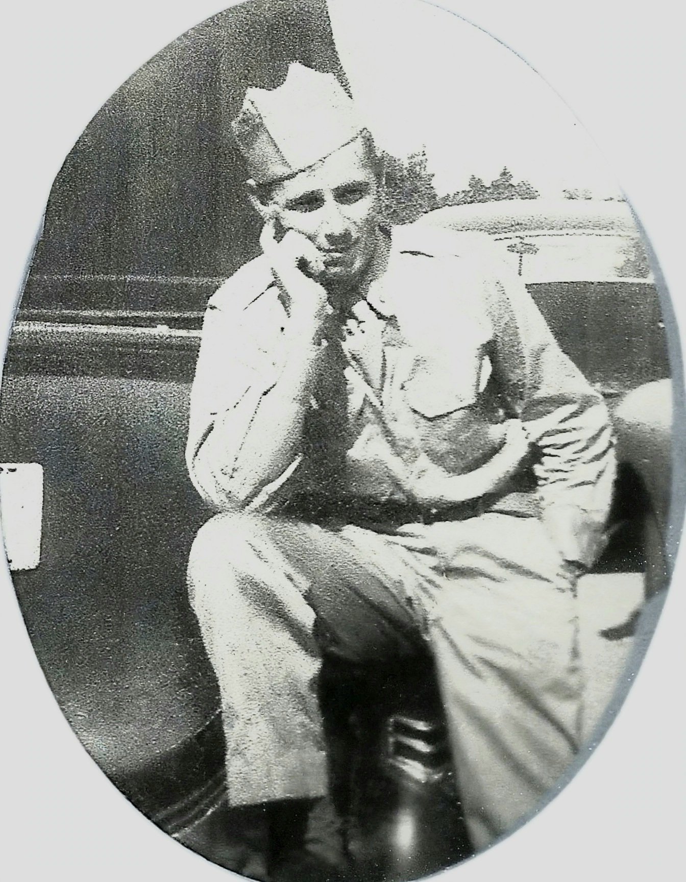An oval-framed black-and-white soldier portrait, badly faded, before restoration